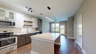 Located at 2470 Cheshire Bridge Rd NE in Atlanta, GA, this well-appointed one-bedroom, one-bathroom unit offers a thoughtfully designed open-concept layout with modern finishes throughout. Rich hardwood-style flooring anchors the main living areas, creating a warm and cohesive aesthetic. The kitchen is a standout feature, showcasing a large central island with quartz countertops, a striking mix of white upper cabinetry and dark wood-toned lower cabinets, subway tile backsplash, stainless steel appliances, and both pendant and track lighting. The kitchen flows seamlessly into the living area, which benefits from natural light through a large window and is finished with a ceiling fan. The spacious bedroom features plush carpeting, a ceiling fan, and a window with outdoor views of surrounding greenery, offering a calm retreat. The bathroom is elegantly appointed with a dual-sink vanity, dark wood cabinetry, a large framed mirror, and hardwood-style flooring that continues from the main areas. A dedicated walk-in closet with built-in wire shelving provides ample storage. The overall ambiance is clean, contemporary, and functional — ideal for modern urban living in Atlanta.