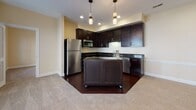 Located at 4437 Glengarry Dr in Beavercreek, Ohio, this two-story home offers a well-designed layout with thoughtful finishes throughout. The kitchen serves as a centerpiece of the main level, showcasing rich dark wood cabinetry, granite countertops, stainless steel appliances including a refrigerator, range, microwave, and dishwasher, and a movable center island accented by pendant lighting overhead. Hardwood flooring grounds the kitchen space, which flows seamlessly into the adjacent living areas. The bathrooms are finished with light sage-green walls, large-format tile flooring, and clean white fixtures. One full bathroom features a soaking tub and shower combination alongside a natural light-filled window, while another includes a dark espresso vanity with a white countertop and a large mirror. A convenient half bath is tucked beneath the staircase. The bedrooms are carpeted and well-sized, each benefiting from multiple windows that invite natural light. Ceiling fans are present in several rooms for added comfort. One bedroom is positioned adjacent to a stacked washer and dryer unit, providing in-unit laundry convenience. The warm, neutral color palette and consistent finishes throughout create a cohesive and inviting atmosphere across both floors.
