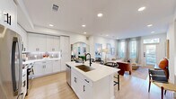 Located at 5300 N Mays St in Georgetown, TX, this thoughtfully designed 2-bedroom, 3-bathroom residence offers a cohesive open-concept layout finished with light hardwood flooring, recessed lighting, and a crisp white palette throughout. The kitchen is a standout feature, equipped with white shaker cabinetry, a decorative tile backsplash, stainless steel appliances, and a central island with a matte black faucet and bar seating — ideal for both cooking and casual dining. The kitchen flows seamlessly into the living room, which is bathed in natural light from large windows and a glass door with transom window that opens to the outdoors. The primary bedroom is a comfortable retreat with ample natural light and direct access to a well-appointed en-suite bathroom, which features a dual-sink vanity with white countertops, matte black fixtures, a glass-enclosed shower, and a dedicated walk-in closet with built-in shelving and dual hanging rods. The second bedroom also benefits from generous window coverage and bright, airy interiors. Two additional closets provide practical storage throughout. The clean, modern aesthetic and efficient use of space make this Georgetown residence a refined and functional home.