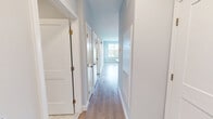 Located at 4 Gilbert Dr in Merrimack, NH, this thoughtfully designed 2-bedroom, 2-bathroom residence offers a clean, contemporary aesthetic across its single floor. The open kitchen and living area serves as the heart of the home, showcasing crisp white cabinetry, quartz countertops with a subtle speckled finish, a tile backsplash, and a full suite of stainless steel appliances including a range, over-the-range microwave, dishwasher, and refrigerator. A kitchen island provides additional prep and gathering space.

Light wood-tone flooring extends throughout the living areas and bedrooms, complementing the soft neutral gray walls and white trim for a cohesive, modern look. The spacious primary bedroom offers generous room to furnish comfortably, while the second bedroom features a large window with views of a lush green landscape and balcony access. Both rooms include dedicated closets.

The two full bathrooms are finished with marble-style tile flooring, warm wood-toned vanities with brushed gold hardware, white quartz countertops, and full tub-shower combinations. Natural light flows through well-placed windows in each room, enhancing the bright, airy feel throughout this well-appointed Merrimack residence.