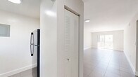 Located at 13890 NE 3rd Ct in Miami, FL, this 2-bedroom, 1-bathroom unit offers a well-organized single-floor layout with a clean, minimalist aesthetic throughout. Large-format neutral tile flooring runs seamlessly across every room, lending a cohesive and easy-to-maintain feel to the entire space.

The living room is bright and open, featuring recessed lighting and a sliding glass door that leads to a private balcony, allowing natural light to fill the room. The kitchen is outfitted with sleek white cabinetry, light stone countertops, an undermount sink, and a stainless steel refrigerator, offering a fresh, modern workspace.

Both bedrooms are well-proportioned, each featuring a ceiling fan with integrated lighting and windows that bring in natural light and outdoor views of the surrounding greenery. The primary bedroom includes a double louvered-door closet for ample storage. The second bedroom mirrors the same clean design and comfortable scale.

The bathroom features classic white subway tile lining the tub surround, a shower-tub combo, and a window for natural ventilation. A hallway connects the rooms efficiently, rounding out this functional and neatly designed Miami residence.