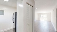 Located at 13890 NE 3rd Ct in Miami, FL, this 2-bedroom, 1-bathroom unit offers a well-organized single-floor layout with a clean, minimalist aesthetic throughout. Large-format neutral tile flooring runs seamlessly across every room, lending a cohesive and easy-to-maintain feel to the entire space.

The living room is bright and open, featuring recessed lighting and a sliding glass door that leads to a private balcony, allowing natural light to fill the room. The kitchen is outfitted with sleek white cabinetry, light stone countertops, an undermount sink, and a stainless steel refrigerator, offering a fresh, modern workspace.

Both bedrooms are well-proportioned, each featuring a ceiling fan with integrated lighting and windows that bring in natural light and outdoor views of the surrounding greenery. The primary bedroom includes a double louvered-door closet for ample storage. The second bedroom mirrors the same clean design and comfortable scale.

The bathroom features classic white subway tile lining the tub surround, a shower-tub combo, and a window for natural ventilation. A hallway connects the rooms efficiently, rounding out this functional and neatly designed Miami residence.