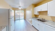 Located at 2400 Arden Way in the Arcade neighborhood of Sacramento, CA, this single-story 2-bedroom, 1-bathroom unit offers a straightforward and functional layout throughout. The interior features light wood-style flooring that runs consistently across the main living areas, complemented by warm beige-toned walls and textured ceilings that give the space a cohesive, neutral aesthetic.

The open living area is generously proportioned, providing ample room for flexible furniture arrangements. A wall-unit air conditioner ensures year-round comfort, and natural light filters in through blinds-equipped windows. The layout connects seamlessly to the kitchen and dining area, which is brightened by a ceiling fan and sliding glass doors leading to an outdoor patio — an ideal feature for indoor-outdoor living.

The kitchen is well-appointed with white shaker-style cabinetry, granite-look countertops, a stainless steel sink, and white appliances including a full-size refrigerator. Both bedrooms are comfortably sized with large windows that allow for good natural light and offer views of the surrounding greenery.

The bathroom features a full tub-shower combination with white tile surround, a natural light window, and tile flooring. Throughout the unit, clean white baseboards and consistent finishes contribute to a tidy and move-in ready presentation.