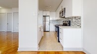 Located at 45 Balliol St in Toronto's vibrant Midtown neighbourhood, this well-appointed one-bedroom, one-bathroom unit offers a thoughtfully designed layout across a single floor. Polished parquet hardwood flooring flows throughout the living spaces, lending warmth and character to the interior.

The open-concept kitchen and living area forms the heart of the unit. The kitchen has been renovated to a modern standard, featuring sleek white cabinetry, a stone-topped island with breakfast bar, a mosaic tile backsplash, and a full suite of stainless steel appliances including a dishwasher, range, and over-the-range microwave. Large-format tile flooring completes the kitchen area.

Floor-to-ceiling windows span the living room and bedroom, flooding both spaces with abundant natural light and offering open city views of the surrounding Midtown Toronto skyline. Baseboard heating runs beneath the windows throughout. The bedroom is a comfortable size, featuring double closet doors and direct access to the balcony through full-height glazing.

The bathroom is finished with large-format stone-look wall tiles surrounding a soaking bathtub, chrome fixtures, and a mirrored medicine cabinet, creating a clean and contemporary aesthetic throughout.