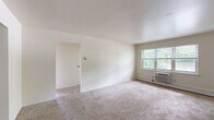 Located at 1 Hillside Ave in Rockaway, NJ, this single-floor unit offers three bedrooms, one bathroom, a kitchen, a living room, and a hallway in a well-organized layout. The living room is generously sized, featuring wall-to-wall carpeting, a baseboard heating unit, a window air conditioning unit, and natural light streaming in through a large window. A closet and entry door add functional convenience to the space. The kitchen transitions seamlessly from the living area, showcasing wood-style hard flooring, rich dark cabinetry, a tile backsplash, and white appliances including a range and refrigerator, with a window providing natural light. The three bedrooms are carpeted and neutral in tone, each featuring baseboard heating. The spacious primary bedroom benefits from dual windows that bring in ample natural light and offer neighborhood views. The additional bedrooms are well-proportioned and bright. The bathroom is a standout feature, finished with large-format travertine-style tiles on the floor and surrounding the tub-shower combo, accented by a decorative mosaic border strip and fitted with chrome fixtures, completing the space with a polished, refined touch.