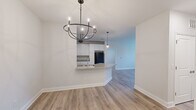 Located at 1 Clubhouse Way in Lavonia, Georgia, this well-appointed 2-bedroom, 2-bathroom single-story home offers a clean, modern aesthetic with consistent finishes throughout. Light wood-look flooring flows seamlessly across every room, complementing the bright white walls and crisp trim work.

The open-concept kitchen is a standout feature, showcasing white shaker-style cabinetry extending to the ceiling for ample storage, granite countertops, a center island with a built-in sink, and black appliances including a range, microwave, and refrigerator. Pendant lighting above the island and a stylish chandelier in the adjoining dining area add a polished touch to the shared living space.

Both bedrooms are comfortably sized with large windows that invite natural light and provide pleasant outdoor views of the surrounding greenery. The primary bedroom offers a generous footprint with dedicated closet space. Hallways are bright and well-proportioned, connecting all areas of the home with ease.

Each bathroom features white vanity cabinetry, granite countertops, large mirrors, and a tub-shower combination, maintaining the home's cohesive and clean design language. The overall ambiance is fresh, neutral, and move-in ready, making this home a functional and attractive residence.