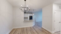 Located at 1 Clubhouse Way in Lavonia, Georgia, this well-appointed 2-bedroom, 2-bathroom single-story home offers a clean, modern aesthetic with consistent finishes throughout. Light wood-look flooring flows seamlessly across every room, complementing the bright white walls and crisp trim work.

The open-concept kitchen is a standout feature, showcasing white shaker-style cabinetry extending to the ceiling for ample storage, granite countertops, a center island with a built-in sink, and black appliances including a range, microwave, and refrigerator. Pendant lighting above the island and a stylish chandelier in the adjoining dining area add a polished touch to the shared living space.

Both bedrooms are comfortably sized with large windows that invite natural light and provide pleasant outdoor views of the surrounding greenery. The primary bedroom offers a generous footprint with dedicated closet space. Hallways are bright and well-proportioned, connecting all areas of the home with ease.

Each bathroom features white vanity cabinetry, granite countertops, large mirrors, and a tub-shower combination, maintaining the home's cohesive and clean design language. The overall ambiance is fresh, neutral, and move-in ready, making this home a functional and attractive residence.
