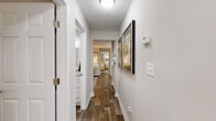 This single-floor, 2-bedroom, 2-bathroom residence offers a thoughtfully designed layout that maximizes comfort and functionality. The living room serves as the heart of the home, featuring a white brick fireplace, wood-look flooring, and a sliding glass door that fills the space with natural light and provides access to an outdoor area. Adjacent to the living room, the dining area accommodates a dedicated dining space highlighted by bold artwork and a large accent mirror.

The galley-style kitchen is well-equipped with white shaker cabinetry, granite-style countertops, stainless steel appliances, and ample storage throughout. A hallway lined with framed artwork connects the main living spaces to the private quarters, with two closets and a dedicated laundry room — complete with washer/dryer hookups and wire shelving — adding practical storage solutions.

The spacious primary bedroom features wood-look flooring, a large window with natural light, and generous closet space. The second bedroom is equally comfortable. Both bathrooms include tub-shower combinations and wood-look flooring. Throughout the residence, a cohesive neutral palette with warm yellow accents creates a bright and inviting ambiance.