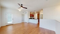 Located at 357 Windigrove Dr in Waynesboro, Virginia, this two-bedroom, two-bathroom residence spans two floors and offers a well-designed layout with quality finishes throughout. The main level features an open-concept kitchen and living area with warm hardwood-style flooring, crown molding, and a ceiling fan that enhances airflow and comfort. The kitchen is a standout, showcasing rich wood cabinetry, dark granite countertops, stainless steel appliances including a range and over-the-range microwave, and a peninsula with pendant lighting — ideal for both cooking and casual dining. The living area benefits from natural light and a clean, neutral palette. Both bedrooms are carpeted and equipped with ceiling fans; the primary bedroom is generously sized with a walk-in closet featuring wire shelving and an en-suite bathroom complete with a soaking tub, granite vanity, and hardwood-style flooring. The second bedroom also offers comfortable proportions and a dedicated closet. A dedicated laundry room houses a full-size washer and water heater. A utility room and two staircases complete the functional layout, making this a practical and well-appointed home.