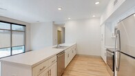 Located at 8000 Arlington Expressway in Jacksonville, FL, this well-appointed 2-bedroom, 2-bathroom residence offers a clean, contemporary design throughout its single-level layout. Light wood-style flooring flows consistently across all rooms, complemented by crisp white walls and recessed lighting that create a bright, welcoming atmosphere.

The open-concept living, dining, and kitchen area serves as the heart of the home. The kitchen is outfitted with white shaker-style cabinetry featuring brushed nickel hardware, a large peninsula with a white countertop and undermount sink, and a full suite of stainless steel appliances including a refrigerator, range, microwave, and dishwasher. Abundant recessed lighting illuminates the space effectively.

Both bathrooms are finished with white vanity cabinetry, white countertops, and framed mirrors. One bathroom features an accessible walk-in shower with grab bars, while the second includes a glass-enclosed shower stall. The bedrooms are generously sized, with large windows allowing ample natural light. The primary bedroom connects to a well-organized walk-in closet with wire shelving systems. A dedicated laundry area and multiple additional closets provide practical storage throughout. The hallway leads seamlessly between all rooms, reinforcing the unit's efficient and functional floor plan.
