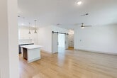Located at 6735 Standifer Gap Rd in Chattanooga, TN, this well-appointed 2-bedroom, 1-bathroom single-story home offers a thoughtfully designed open-concept layout with modern finishes throughout. Light wood flooring flows seamlessly across the main living areas, creating a bright and cohesive aesthetic.

The kitchen and living room share an open, airy footprint ideal for everyday living. The kitchen is outfitted with two-tone cabinetry — crisp white uppers and gray lowers — complemented by a white subway tile backsplash, quartz countertops, stainless steel appliances, and a central island with pendant lighting overhead. A ceiling fan anchors the adjacent living area, which also features a distinctive sliding barn door that adds a stylish architectural touch.

The spacious primary bedroom features hardwood-style flooring, a large window overlooking greenery, and a ceiling fan, creating a comfortable and light-filled retreat. The secondary bedroom offers carpeted flooring, natural light, and outdoor views. Both rooms are served by a well-appointed full bathroom featuring a soaking tub with a marble-tiled surround, a gray vanity with quartz countertop, and wood-look flooring. A dedicated closet rounds out the functional layout of this clean, move-in-ready Chattanooga home.