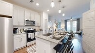 Located in Stone Mountain, GA, this thoughtfully designed 2-bedroom, 2-bathroom residence offers a seamless open-concept floor plan that maximizes every square foot. The kitchen is a standout feature, showcasing white shaker cabinetry, a subway tile backsplash, stainless steel appliances, granite countertops, and a spacious island with bar seating illuminated by elegant pendant lighting — ideal for both cooking and casual dining. Hardwood-style flooring flows throughout the main living areas, adding warmth and continuity. The living room is bright and inviting, benefiting from large windows that usher in natural light, and is topped with a ceiling fan for year-round comfort. A private balcony extends the living space outdoors. The primary bedroom is generously sized and features plush carpeting, ample natural light, and a dedicated walk-in closet with built-in shelving. The second bedroom is equally comfortable with its own closet. Both bathrooms are clean and functional, with one featuring a soaking tub and shower combo alongside wood-look flooring. The overall aesthetic is modern and cohesive, with a bright, neutral palette that creates an airy and welcoming ambiance throughout.
