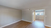 Located at 6131 North 16th Street in Phoenix, AZ, this one-bedroom, two-bathroom unit offers a well-organized single-floor layout designed for comfortable everyday living. Wood-look flooring runs throughout the entire space, providing a clean and cohesive aesthetic from room to room.

The combined kitchen and living area forms the heart of the home. The kitchen is outfitted with white shaker-style cabinetry reaching toward the ceiling, stainless steel appliances including a range, over-the-range microwave, and refrigerator, complemented by light countertops and a window that invites natural light.

The living area is open and neutral, with soft gray walls and large windows that frame views of the surrounding greenery, maintaining a bright and airy atmosphere. The front entry also benefits from a sizable window, further enhancing the natural light throughout.

The bedroom offers a comfortable footprint with a closet, a window with exterior views, and the same consistent flooring and neutral tones found throughout the unit.

A hallway connects the bedroom to the two bathrooms. One bathroom features a tub-shower combination with chrome fixtures and a clean white finish. A vanity with white cabinetry and a mirror is accessible from the corridor, alongside sliding closet doors that provide additional storage. The overall design is clean, modern, and move-in ready.