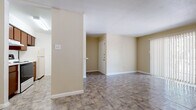 Located at 5880 W Gulf Bank Rd in Houston, TX, this single-floor unit offers a straightforward and functional layout designed for comfortable everyday living. The interior is finished with durable tile flooring throughout, set against warm beige walls and clean white trim, creating a cohesive and neutral aesthetic across all rooms.

The main living area is generously proportioned, featuring a sliding glass door with vertical blinds that opens to an outdoor area, allowing natural light to fill the space. A separate room connected via a hallway provides additional flexibility and also benefits from natural light through a window with blinds. The open layout is supported by ceiling vents for climate control.

The galley-style kitchen is efficiently arranged with dark wood cabinetry on both sides, white countertops, a white range, dishwasher, and a double-basin sink — providing ample storage and workspace. An interior door off the kitchen leads to a utility area.

The bedrooms are well-sized, each featuring windows with blinds that invite natural light and outdoor views. The bathroom includes a wood-toned vanity with a white countertop and sink, a toilet, and a tub-shower combination with white tile surround. A hallway connects the private areas of the unit seamlessly to the main living spaces.