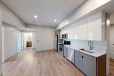 Located at 100 Hemenway Street in Boston's Fenway neighborhood, this three-bedroom, two-bathroom unit offers a well-designed, modern interior across a single floor. The open-concept kitchen, dining, and living area serves as the heart of the home, featuring light hardwood-style flooring, recessed lighting, and a sleek, contemporary kitchen equipped with stainless steel appliances including a refrigerator, range, microwave, and dishwasher. Cabinetry combines high-gloss white upper cabinets with matte gray lower cabinets, complemented by light stone countertops and a subway tile backsplash. The three bedrooms are carpeted for comfort, each featuring neutral gray walls and windows that invite natural light and neighborhood views. The primary bedroom includes a double closet with paneled doors and matte black hardware. The unit features four closets total, providing ample storage throughout. The two bathrooms are finished with modern tile flooring and wood-toned vanities topped with stone counters. The full bathroom includes a windowed walk-in shower with classic subway tile surround, while the second bathroom offers a clean, functional layout. A dedicated entrance and a consistent neutral color palette throughout give the unit a cohesive, contemporary feel.