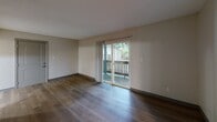 Located at 217 W Broadway in Columbia, Missouri, this 2-bedroom, 1-bathroom unit offers a practical and well-organized single-floor layout. The living room features rich, dark wood-style flooring and a sliding glass door that opens to a private balcony, allowing natural light and outdoor views to fill the space. The kitchen is efficiently designed with warm honey-toned cabinetry, a white tile backsplash, a peninsula with a white countertop, and black appliances including a range, dishwasher, and refrigerator — providing ample workspace and storage. Both bedrooms are finished with light wood-style flooring and neutral walls, each benefiting from windows fitted with blinds that invite natural light while maintaining privacy. The primary bedroom offers a comfortable footprint with direct hallway access. The second bedroom is similarly appointed, making it well-suited as a guest room or home office. A connecting hallway with a closet links the main living areas to the bedrooms. The full bathroom includes a tiled tub-shower combination, tile flooring, and safety grab bars. Textured ceilings are consistent throughout the unit, adding a classic residential character to the overall space.