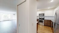 Located at 2730 Hazelwood St in Maplewood, MN, this 2-bedroom, 3-bathroom residence offers a well-designed single-floor layout with a thoughtful blend of modern updates and comfortable living spaces. The kitchen is a standout feature, showcasing two-tone cabinetry with rich wood lower cabinets and crisp white uppers, a classic subway tile backsplash, gray countertops, and a full suite of stainless steel appliances, all set atop warm hardwood-style flooring. The living room is bright and inviting, with large bay windows that frame views of the surrounding greenery and allow abundant natural light to fill the space. Hardwood-style flooring continues throughout the main living areas, complemented by baseboard heating. Both bedrooms are carpeted and well-lit, with the primary bedroom offering generous proportions, multiple windows, a ceiling fan, and ample closet space. A dedicated walk-in closet features built-in wire shelving for organized storage. The three bathrooms are finished with contemporary tile work, including one with floor-to-ceiling gray tile in the walk-in shower, and another featuring a long vanity with a white countertop and dark cabinetry. Clean white walls and modern chrome fixtures complete the polished, move-in-ready aesthetic throughout.