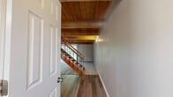 Located at 2901 County Line Rd in Kettering, Ohio, this two-story home offers 2 bedrooms and 2 bathrooms distributed across two well-balanced floors. The main level encompasses an entrance, a galley-style kitchen, and staircase access, while the upper level houses the bedrooms, bathrooms, hallway, and a closet. The kitchen is a functional highlight, featuring white shaker-style cabinetry, granite-look countertops, stainless steel appliances including a refrigerator and dishwasher, light wood-look flooring, and a window that brings in natural light and outdoor views. A warm wood-paneled ceiling accent adds character to the kitchen space. Both bedrooms are finished with soft, neutral-toned carpet and feature large windows that allow ample natural light to fill the rooms. The generously sized primary bedroom offers a comfortable retreat with good proportions. The secondary bedroom includes a double-door closet for added storage. The bathrooms are well-appointed with white cabinetry, granite-look countertops, wood-look flooring, and a tub-shower combination. Throughout, the home maintains a clean, neutral palette of warm gray and white tones, creating a bright and cohesive atmosphere suitable for a variety of interior styles.