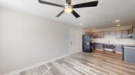 Located at 4115 Meadows Dr in Indianapolis, Indiana, this single-floor, 4-bedroom, 2-bathroom home offers a practical and well-appointed layout designed for comfortable everyday living. Light-toned luxury vinyl plank flooring runs throughout the main living and kitchen areas, complementing the neutral color palette that gives the home a clean, modern feel.

The kitchen features rich, dark-stained cabinetry with sleek hardware, light countertops, and black appliances including a refrigerator, electric range, and dishwasher. Recessed lighting brightens the space, which flows naturally into the main living area. The living room is generously proportioned, finished with the same wood-look flooring, a ceiling fan with light fixture, and a multi-pane window that invites natural light.

Each of the four bedrooms is carpeted for warmth and comfort, and ceiling fans provide year-round climate control. The primary bedroom is a well-sized retreat, and closet storage is available throughout, including a walk-in closet in one bedroom. Both bathrooms feature dark-stained vanities with light countertops and wood-look flooring; one bathroom is equipped with accessibility grab bars.

A dedicated laundry room houses a side-by-side Amana front-load washer and dryer, adding everyday convenience to this well-rounded home.