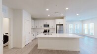 Located at 1801 Riverside Parkway in Douglasville, GA, this well-appointed 2-bedroom, 2-bathroom residence offers a thoughtfully designed single-level layout with modern finishes throughout. The open-concept kitchen serves as the heart of the home, showcasing crisp white shaker cabinetry with matte black hardware, a subway tile backsplash, gleaming quartz countertops, and a large center island with an integrated sink. Stainless steel appliances — including a refrigerator, range, microwave, and dishwasher — complete the space, while in-unit laundry adds everyday convenience. Light wood-tone flooring flows through the main living and kitchen areas, complemented by recessed lighting and large windows that invite natural light. The spacious living area features clean white walls and additional windows with views to the outdoors. The primary bedroom is generously sized, complete with a ceiling fan, plush carpeting, a private en-suite bathroom, and a walk-in closet outfitted with wire shelving systems. The second bedroom mirrors the same comfortable feel with carpet and a ceiling fan. Both bathrooms feature tile flooring, white vanities, and tiled tub-shower combinations. A second walk-in closet provides ample additional storage, rounding out this clean, contemporary residence.