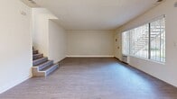 Located at 627 S Velare St, Unit 34 in Anaheim, CA, this 2-bedroom, 3-bathroom unit offers a practical and well-organized layout across a single floor. The living area features light wood-look flooring, crisp white walls, and a textured ceiling, creating a bright and clean atmosphere. A staircase with wood-toned steps adds architectural interest and connects different levels of the space. Large windows dressed with vertical blinds allow natural light to fill both the living room and bedrooms, enhancing the open, airy feel throughout. The kitchen is outfitted with white cabinetry, gray stone-look countertops, a stainless steel gas range, an over-the-range microwave, and a bold mosaic tile backsplash that adds a touch of visual contrast. Light tile flooring completes the kitchen's clean, functional aesthetic. The primary bedroom offers a comfortable footprint with ample natural light, while the second bedroom is similarly bright and versatile. All three bathrooms maintain a consistent clean design, with one featuring a tub-shower combination with white tile surround and tile flooring. Throughout the unit, the neutral color palette and consistent flooring create a cohesive, move-in-ready environment.