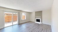 Located in Sacramento's Greenhaven neighborhood, this single-story, 3-bedroom, 2-bathroom home offers a well-designed, functional layout across a comfortable footprint. The open living room is anchored by a classic fireplace with a white mantel, complemented by light wood-style vinyl flooring and a textured ceiling. A ceiling fan adds comfort, and sliding glass doors open to a private, wood-fenced patio, filling the space with natural light. The kitchen is equipped with slate-gray shaker cabinets, white quartz countertops, a breakfast bar peninsula, stainless steel appliances including a dishwasher and refrigerator, a deep single-basin sink, and track lighting overhead. The three bedrooms feature plush carpeting and sliding closet doors, with windows that offer views of the surrounding greenery. The primary bedroom provides a generous amount of space with ample closet storage. Both bathrooms are finished with gray vanity cabinetry, white quartz countertops, and wood-style flooring. The full bathroom includes a tub-shower combo with sliding glass doors and a large mirror, while the second bathroom offers a clean, minimalist design. A hallway connects all rooms efficiently throughout the single-floor layout.