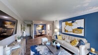 This well-appointed two-bedroom, one-bathroom single-story residence in Hattiesburg, Mississippi, offers a thoughtfully designed layout that balances comfort and style. The open-concept living and dining area serves as the heart of the home, distinguished by rich wood-style flooring, crisp crown molding, and striking blue accent walls that lend a bold yet cohesive aesthetic throughout. The living room is generously proportioned, featuring sliding glass doors that invite natural light and provide outdoor access. A dedicated dining nook, framed by chair rail molding and a vibrant accent wall, provides an intimate setting for meals. The galley-style kitchen is efficiently arranged with white shaker cabinetry, granite-look countertops, subway tile backsplash, and stainless steel appliances, offering ample storage and counter space. The primary bedroom features plush carpeting, a ceiling fan, a walk-in closet, and a coordinating blue accent wall. The second bedroom also offers carpeted floors and a generous closet. The full bathroom is finished with white cabinetry, granite countertops, and a tiled tub-shower combination, delivering a clean, modern feel throughout.