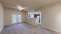 This single-story, one-bedroom, one-bathroom home offers a thoughtfully designed layout that maximizes comfort and functionality. The open-concept living room is carpeted and bathed in natural light through large French doors, and features a ceiling fan and track lighting, creating a bright and airy atmosphere. It flows seamlessly into the kitchen via a pass-through peninsula with granite-style countertops, rich cherry wood cabinetry, and stainless steel appliances including a refrigerator, microwave, and dishwasher. A dedicated dining area adjacent to the kitchen benefits from large windows and its own ceiling fan, with wood-look flooring adding warmth to the space. The full bathroom is finished with matching wood cabinetry, a single-sink vanity, and a soaking tub, with wood-look flooring throughout. The spacious bedroom features plush carpet, a ceiling fan, and a large window overlooking greenery, offering a peaceful retreat. A generously sized walk-in closet with built-in wire shelving provides ample storage. A dedicated in-unit laundry room accommodates a full-size washer and dryer side by side and includes additional shelving. A hallway connects all areas efficiently, completing this well-organized and functional home.