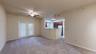 This single-story, one-bedroom, one-bathroom home offers a thoughtfully designed layout that maximizes comfort and functionality. The open-concept living room is carpeted and bathed in natural light through large French doors, and features a ceiling fan and track lighting, creating a bright and airy atmosphere. It flows seamlessly into the kitchen via a pass-through peninsula with granite-style countertops, rich cherry wood cabinetry, and stainless steel appliances including a refrigerator, microwave, and dishwasher. A dedicated dining area adjacent to the kitchen benefits from large windows and its own ceiling fan, with wood-look flooring adding warmth to the space. The full bathroom is finished with matching wood cabinetry, a single-sink vanity, and a soaking tub, with wood-look flooring throughout. The spacious bedroom features plush carpet, a ceiling fan, and a large window overlooking greenery, offering a peaceful retreat. A generously sized walk-in closet with built-in wire shelving provides ample storage. A dedicated in-unit laundry room accommodates a full-size washer and dryer side by side and includes additional shelving. A hallway connects all areas efficiently, completing this well-organized and functional home.