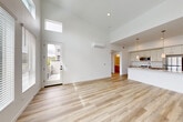Located at 2611 First St in Napa, CA, this thoughtfully designed one-bedroom, one-bathroom residence offers a bright, modern living experience across a single floor. The open-concept living, dining, and kitchen area is the heart of the home, boasting dramatically high ceilings with clerestory windows that flood the space with natural light. Light-toned hardwood flooring runs throughout, enhancing the airy, contemporary feel. A wall-mounted mini-split system provides efficient climate control.

The kitchen features a central island with a sleek quartz countertop, an undermount sink, pendant lighting, white upper cabinetry, warm wood lower cabinetry, and stainless steel appliances including a refrigerator, range, and microwave. A sliding door in the living area opens to a private balcony with hillside views of the Napa landscape.

The bedroom is finished with plush carpeting and includes a sliding glass door to its own balcony, offering peaceful outdoor access and scenic views. A dedicated closet provides ample storage. The bathroom is clean and functional, featuring wood-toned cabinetry, a quartz vanity, and a tub/shower combination. In-unit laundry completes this well-appointed residence.