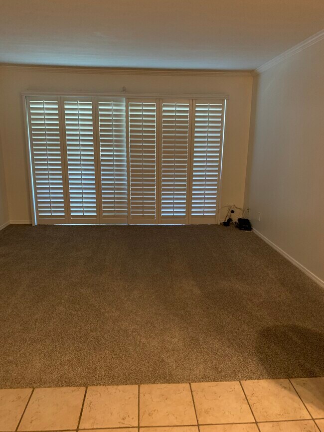 Sala de estar con alfombra y pintura nuevas. Puertas corredizas que dan a la terraza. - 436 N Bellflower Blvd