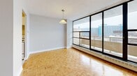 This 510 square foot apartment in Toronto offers a well-designed living space within a compact footprint. The unit features one bedroom, one bathroom, and an open-concept living area. Throughout the apartment, beautiful parquet flooring adds warmth and character, while large windows flood the space with natural light.

The living room is spacious and versatile, with ample room for seating and entertainment. It opens onto a balcony through sliding glass doors, providing outdoor space and city views. The bedroom, measuring 110 square feet, comfortably accommodates a queen-sized bed and essential furniture.

The kitchen, though compact, is efficiently designed with white cabinetry, a stainless steel sink, and a full-sized electric range. The bathroom features clean, white tiling and a standard bathtub-shower combination.

The apartment's neutral color palette, dominated by light grey walls and white trim, creates a bright and airy atmosphere. This, combined with the open layout, makes the space feel larger than its actual square footage. The unit's design maximizes functionality in a limited area, making it an ideal choice for urban living in Toronto.