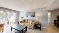 Located at 1885 Harper Dr in Lake City, Georgia, this single-story, 2-bedroom, 1-bathroom home offers a thoughtfully organized layout across a comfortable footprint. The living room welcomes you with neutral gray walls, light wood-style flooring, and a textured ceiling, while a sliding glass door fills the space with natural light and provides outdoor access. Adjacent to the living area, the dedicated dining room features the same light flooring and neutral tones, creating a seamless flow throughout the main living spaces. The galley-style kitchen is well-equipped with white cabinetry, dark granite countertops, stainless steel appliances including a gas range, dishwasher, and refrigerator, and conveniently houses an in-unit washer and dryer. The spacious primary bedroom includes a ceiling fan and direct access to the bathroom, while the second bedroom also features a ceiling fan and a closet. The full bathroom is finished with white cabinetry, dark granite countertops, a single vanity with mirror, and a tub-shower combination. Consistent neutral tones, light flooring, and ceiling fans throughout give the home a cohesive, comfortable feel.