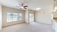 Located at 3770 Blue Ct in Columbus, Indiana, this single-floor residence offers a thoughtfully designed layout with two bedrooms, two bathrooms, and a generous overall footprint. The open-concept living and dining area is bright and welcoming, featuring plush carpeting, a ceiling fan with light fixture, and large windows that allow abundant natural light to fill the space. A sliding glass door leads directly to a private balcony, extending the living area outdoors. The kitchen is positioned adjacent to the main living space and features dark cabinetry, dark granite countertops, a breakfast bar with pendant lighting overhead, and black appliances, creating a clean and functional cooking environment. Both bedrooms are carpeted and well-proportioned, with the primary bedroom offering ample space and access to a dedicated closet area. The residence is notably well-appointed with six closets throughout, providing exceptional storage. Both bathrooms feature tile flooring, dark vanity cabinetry with granite countertops, and large mirrors. One bathroom includes a soaking tub and shower combination. Carpeted hallways connect the rooms seamlessly, and an in-unit laundry area adds everyday convenience. The neutral color palette and clean finishes throughout give the space a move-in-ready feel.