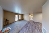 Located on Martin Luther King Jr Way in Seattle, WA, this single-floor residence offers four bedrooms, two full bathrooms, and a thoughtfully organized layout. The open living area combines warm-toned walls with a mix of plush carpet and wood-look flooring, creating a comfortable, welcoming atmosphere. Double doors in the living room lead directly to a private balcony, bringing in natural light and outdoor views. The adjacent dining room provides a dedicated space for meals, while the galley-style kitchen is equipped with ample light wood cabinetry, dark countertops, black appliances including a refrigerator and electric range, and a utility sink — offering everything needed for everyday cooking. A hallway connects the living spaces to the four bedrooms, each featuring soft carpet flooring and natural light from well-placed windows. The bedrooms are supported by an impressive seven closets distributed throughout the unit, ensuring abundant storage. Both bathrooms include wood-look tile flooring, vanities with dark countertops, and tub-shower combinations. A dedicated in-unit laundry room houses a full-size washer and dryer with overhead shelving. The consistent warm neutral palette and practical finishes give the entire space a clean, functional character well-suited for everyday living.