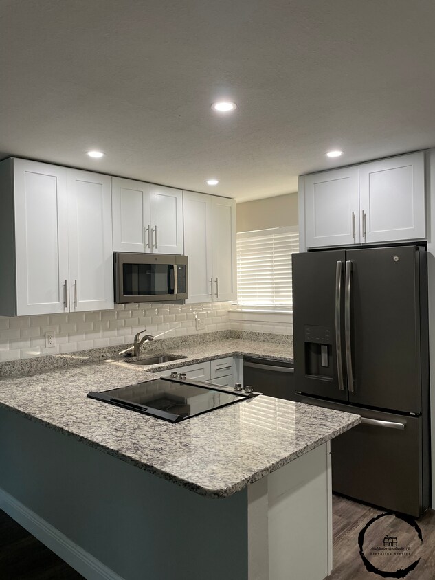 Large granite island with white shaker cabinets to ceiling. - 232 Orienta Point St