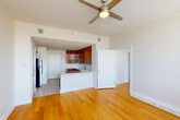 Located in the heart of downtown New Orleans, this one-bedroom, one-bathroom residence at 925 Common St offers a well-designed, efficient layout with modern finishes throughout. The open-concept living, dining, and kitchen area serves as the centerpiece of the home, bathed in natural light from a large bank of floor-to-ceiling windows that frame sweeping views of the New Orleans skyline. A ceiling fan overhead and warm hardwood flooring underfoot contribute to the inviting ambiance of this shared space.

The kitchen is a standout feature, showcasing rich, wood-grain cabinetry that extends to the ceiling, complemented by white countertops, a subway tile backsplash, and a full suite of stainless steel appliances, including a range, microwave, dishwasher, and refrigerator. The bedroom is generously sized, continuing the hardwood flooring and offering ample natural light. Two closets provide excellent storage capacity. The bathroom features warm wood vanity cabinetry, a large mirror, subway tile accents, and light stone-look tile flooring. A dedicated laundry area adds everyday convenience, rounding out this thoughtfully appointed residence in one of New Orleans' most vibrant urban locations.