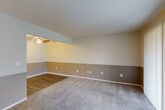 Located at 50631 Jefferson Ave in New Baltimore, MI, this one-bedroom, one-bathroom unit offers a practical and well-organized single-floor layout. The open living and dining area is a standout feature, combining carpet and hardwood-style flooring with two-tone walls — a neutral upper half over a warm taupe lower section — and a ceiling fan overhead that adds both function and character. The combined space feels open and versatile, suitable for a variety of furniture arrangements.

The galley-style kitchen is efficiently designed, featuring white cabinetry on both sides, a white electric range and refrigerator, a single-basin sink with a window above, and hardwood-style flooring that continues the aesthetic from the dining area. The layout maximizes counter and storage space within a compact footprint.

The bedroom is a generously sized private retreat with plush carpet, a window fitted with vertical blinds allowing natural light, and access to the hallway. Three closets throughout the unit provide ample storage. The full bathroom includes a tiled tub and shower combination, a toilet, and a vanity with a light countertop, all finished with hardwood-style flooring for easy maintenance. The hallway connects all areas of the unit seamlessly, contributing to a cohesive and functional flow throughout the space.