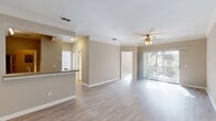 Located in Champions Gate, FL, this well-appointed single-story, 3-bedroom, 2-bathroom home offers a comfortable and functional layout. The open-concept living, dining, and kitchen area forms the heart of the home, finished with light wood-style flooring and neutral tones throughout. Crown molding and ceiling fans add a refined touch to the living space, which is bathed in natural light and opens directly onto a private patio through sliding glass doors, offering pleasant outdoor views.

The kitchen is equipped with stainless steel appliances, including a range, over-the-range microwave, and dishwasher, complemented by warm wood cabinetry, tile backsplash, and a breakfast bar. A dedicated pantry provides additional storage convenience.

The generously sized primary bedroom features multiple windows for natural light and connects to a well-appointed bathroom. Secondary bedrooms are bright and spacious, each with ceiling fans and ample closet space — the home includes six closets in total. An in-unit laundry area and utility room add further practicality. Built-in corner shelving in the hallway offers a thoughtful architectural detail, completing this move-in-ready home.