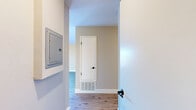 Located at 843 Webster St in Hayward, California, this thoughtfully designed one-bedroom, one-bathroom residence offers a comfortable and efficient layout across a single floor. The open-concept living, dining, and kitchen area serves as the heart of the home, highlighted by striking vaulted ceilings that enhance the sense of space and airiness. Light wood-style flooring runs throughout the main living areas, complementing the warm neutral wall tones. Two sliding glass doors in the living room lead to a private balcony, flooding the space with abundant natural light and offering pleasant views of the surrounding neighborhood and mature trees. A ceiling fan adds comfort to this bright, airy living area. The galley-style kitchen is well-appointed with white shaker cabinetry, light quartz countertops, a decorative hexagonal tile backsplash, and a full suite of stainless steel appliances. The spacious bedroom features plush carpeting, a dedicated closet, and access to a hallway connecting to the rest of the unit. The bathroom is clean and functional, featuring a tiled shower-tub combination with chrome fixtures. A hallway with a utility panel connects all areas of the unit efficiently, completing this well-organized and move-in-ready home.