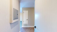Located at 843 Webster St in Hayward, California, this thoughtfully designed one-bedroom, one-bathroom residence offers a comfortable and efficient layout across a single floor. The open-concept living, dining, and kitchen area serves as the heart of the home, highlighted by striking vaulted ceilings that enhance the sense of space and airiness. Light wood-style flooring runs throughout the main living areas, complementing the warm neutral wall tones. Two sliding glass doors in the living room lead to a private balcony, flooding the space with abundant natural light and offering pleasant views of the surrounding neighborhood and mature trees. A ceiling fan adds comfort to this bright, airy living area. The galley-style kitchen is well-appointed with white shaker cabinetry, light quartz countertops, a decorative hexagonal tile backsplash, and a full suite of stainless steel appliances. The spacious bedroom features plush carpeting, a dedicated closet, and access to a hallway connecting to the rest of the unit. The bathroom is clean and functional, featuring a tiled shower-tub combination with chrome fixtures. A hallway with a utility panel connects all areas of the unit efficiently, completing this well-organized and move-in-ready home.