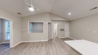 Located at 7100 Claxton Cir in Raleigh, NC, this single-story home offers a thoughtfully designed layout that maximizes every square foot. The open-concept living, dining, and kitchen area serves as the heart of the home, bathed in natural light from large windows and anchored by soaring vaulted ceilings with a ceiling fan overhead. Light-toned luxury vinyl plank flooring flows throughout the main areas, lending a clean, modern aesthetic.

The kitchen is a standout feature, equipped with white shaker cabinets, white quartz countertops, stainless steel appliances including a refrigerator, range, microwave, and dishwasher, and a peninsula with a built-in sink — ideal for both cooking and casual dining.

The spacious primary bedroom features plush carpeting, vaulted ceilings, and a window with outdoor views, creating a calm retreat. It connects to a well-sized closet and has convenient access to the bathrooms. Both bathrooms are finished with white vanities, quartz countertops, and light wood-look flooring, with one featuring a tub-shower combination.

Additional highlights include a dedicated office, a laundry room, a utility room, and an impressive five closets throughout, ensuring ample storage. The neutral color palette and modern finishes create a bright, welcoming ambiance throughout.