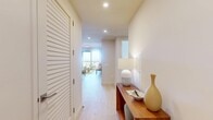 Located at 532 Neptune Ave in Brooklyn's Coney Island neighborhood, this well-appointed 4-bedroom, 2-bathroom residence offers a thoughtfully designed single-floor layout. Light hardwood flooring flows seamlessly throughout, unifying the space with a warm, contemporary aesthetic. A welcoming hallway with recessed lighting and a louvered closet door leads into the open-concept living, dining, and kitchen area. The kitchen is a standout feature, boasting wood-and-white cabinetry, stainless steel appliances, a gas range, and a peninsula with bar seating illuminated by a sleek linear pendant light. The living area opens directly to a balcony through floor-to-ceiling sliding glass doors, offering expansive city views. The four bedrooms are well-proportioned, with the primary bedroom featuring sage-green walls and a large window framing Brooklyn skyline views. Additional bedrooms are bright and airy, with large windows and clean white walls. Two full bathrooms include one with marble-tiled walls, a soaking tub, frameless glass enclosure, and a wood-framed vanity. The unit also includes two closets, an in-unit laundry area, and dedicated storage, completing this functional and stylish Brooklyn residence.