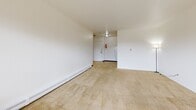 This one-bedroom, one-bathroom unit in West Allis, Wisconsin, offers a practical and efficient layout across a single floor. The living room is a bright, open space with neutral wall tones, plush wall-to-wall carpeting, and baseboard heating, ensuring comfort throughout the seasons. A wall-mounted air conditioning unit provides climate control, and a window allows natural light to filter into the room, creating a welcoming atmosphere.

The galley-style kitchen is thoughtfully laid out with warm wood cabinetry lining both sides, offering ample storage space. White appliances, including a gas range and refrigerator, complement the light countertops and tile flooring, while an overhead exhaust hood adds functional convenience.

The bedroom is a generously sized retreat, also carpeted in the same warm neutral tones as the living area. A large sliding-door closet provides substantial storage, and the room connects seamlessly to the rest of the unit.

The bathroom is clean and well-appointed, featuring tile flooring, a white vanity with cabinet storage, a medicine cabinet mirror, and a shower-tub combination accented with a tasteful mosaic tile surround. The overall design of this unit is straightforward and functional, with a consistent neutral palette throughout that creates a calm, move-in-ready environment.