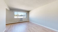 Located at 565 Aldine St in Saint Paul, MN, this one-bedroom, one-bathroom unit offers a well-designed layout across a single floor. The living room is bright and open, featuring light hardwood-style flooring, a textured ceiling, and a large sliding window with an in-unit air conditioner and baseboard heating — keeping the space comfortable year-round. Natural light fills the room, offering views of the surrounding neighborhood.

The galley-style kitchen is efficiently designed with rich, warm-toned wood cabinetry, granite-look countertops, and a full suite of stainless steel appliances including a range, microwave, dishwasher, and refrigerator. Light flooring continues through the kitchen, which connects conveniently to the rest of the unit via a central hallway.

The bedroom is a generously sized retreat, finished with plush wall-to-wall carpeting, a ceiling fan with light fixture, and a window that brings in natural light. Ample storage is provided through multiple closets with bifold doors, including a dedicated closet in the hallway.

The bathroom features full white tile surround in the tub/shower combo, tile flooring, a vanity with granite-look countertops, and warm wood cabinetry, creating a clean and functional space. Overall, the unit offers a practical, comfortable living environment with updated finishes throughout.