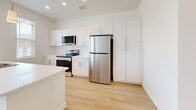 Located on S Cross Hollow Rd in Cedar City, Utah, this single-floor, one-bedroom, one-bathroom residence offers a clean, modern design throughout. Light-toned hardwood-style flooring flows through the main living areas, complementing the bright white walls and creating a fresh, airy atmosphere.

The open-concept kitchen and living area serves as the heart of the home. The kitchen is well-equipped with white shaker cabinetry, light quartz countertops, stainless steel appliances including a refrigerator, electric range, microwave, and dishwasher, as well as a deep single-basin sink. Pendant lighting and windows allowing natural light complete the polished look.

The living area features a glazed door leading to a private balcony with views of the surrounding neighborhood and terrain. The spacious bedroom is carpeted for comfort, features a ceiling fan, dual windows with outdoor views, and includes a dedicated walk-in closet. Vaulted ceilings in the bedroom area add to the sense of openness.

The full bathroom is finished with a tub-shower combination, built-in shelving, brushed nickel fixtures, and hardwood-style flooring. A dedicated laundry room houses a full-size front-loading washer and dryer with additional shelving. This well-designed residence combines functionality and modern style in a convenient Cedar City location.
