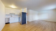Located at 680 Riverview Dr in Columbus, Ohio, this two-bedroom, one-bathroom residence offers a practical and well-maintained single-floor layout. The open-concept living and dining area is bathed in natural light from large windows and features light-toned hardwood-style flooring that extends throughout the common spaces, creating a clean and cohesive aesthetic. The updated kitchen is a standout feature, boasting crisp white shaker cabinetry, a white subway tile backsplash, marble-look countertops, a stainless steel sink with a modern gooseneck faucet, and a full suite of stainless steel appliances including a refrigerator, range, built-in microwave, and dishwasher. The entry area is bright and welcoming, with a window that allows additional natural light. Both bedrooms are carpeted for comfort and include sliding or hinged closet storage. The primary bedroom offers a generous footprint with a window overlooking the surroundings. A baseboard heating system is present throughout the unit. The full bathroom features a white subway-tiled tub and shower surround, hardwood-style flooring, and clean, simple finishes. Multiple closets throughout the hallway provide ample storage for everyday needs.