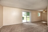 Located at 2927 Madison Ave in Burlington, Iowa, this single-floor, 2-bedroom, 1-bathroom unit offers a practical and comfortable layout across a well-utilized floor plan. The living room is a standout feature, offering generous carpeted space, neutral warm-toned walls, a textured ceiling, and a sliding glass door that fills the room with natural light and provides outdoor views of the surrounding greenery. Adjacent to the living area is a dedicated dining space, creating a seamless flow for everyday living. The kitchen features rich wood cabinetry, a gas range, a double sink, and durable hardwood-style flooring, providing both functionality and warmth. Both bedrooms are carpeted and bathed in natural light from exterior windows with views of the neighborhood. Each bedroom includes closet storage, and the primary bedroom offers a notably spacious footprint with a double-door closet. The full bathroom is well-appointed with a tiled tub-and-shower combination, hardwood-style flooring, and a vanity with granite-style countertop and white cabinetry. A hallway connects the main living areas to the bedrooms, keeping the layout organized and efficient. Two closets provide additional storage throughout the unit.