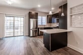 Located at 233 La Grande Ave in Fanwood, NJ, this three-story home offers a well-organized layout with contemporary finishes throughout. The attached garage provides direct interior access and includes built-in shelving along the walls, an automatic door opener, and a dedicated fire sprinkler room, reflecting a commitment to both convenience and safety.

The main living level showcases an open-concept design where the living and dining areas flow seamlessly toward the kitchen. Light wood-tone flooring, recessed lighting, and a ceiling fan contribute to an airy, well-lit atmosphere. A sliding glass door allows natural light to fill the space while providing outdoor access. The kitchen is appointed with dark espresso cabinetry, white countertops, a subway tile backsplash, and a full suite of stainless steel appliances, including a gas range, built-in microwave, dishwasher, and refrigerator.

Bedrooms feature soft carpeting, generous closet space with double doors, and windows fitted with blinds that invite natural light. A full bathroom includes a tub-shower combination enclosed by a sliding glass door, accented with classic white subway tile and a decorative mosaic border. A secondary bathroom features wood-look flooring, a bright window, and clean, neutral finishes throughout.