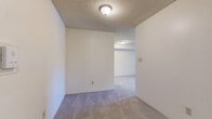 Located at 914 W Lake St, Unit 322 in Fort Collins, Colorado, this two-bedroom, one-bathroom residence offers a practical and well-organized single-floor layout. The unit features wall-to-wall carpeting throughout the main living areas and bedrooms, paired with neutral-toned walls and textured ceilings that lend a clean, consistent aesthetic. Baseboard heating runs along the perimeter of the rooms, ensuring efficient warmth throughout the colder Colorado months. Each bedroom is equipped with windows dressed in vertical blinds, allowing natural light to filter in while offering views of the surrounding greenery. The primary bedroom is a comfortable size and includes a wall-mounted air conditioning unit for year-round climate control. Both bedrooms feature built-in double closets with paneled bi-fold doors, providing ample storage space. The full bathroom includes a tiled tub-shower combination, a toilet, and a vanity with wood cabinetry, finished with tile flooring. The unit's straightforward floor plan connects the living room, bedrooms, bathroom, and closet in an efficient arrangement well-suited for everyday living. Situated in Fort Collins near West Lake Street, residents have convenient access to local amenities and the natural surroundings of the area.